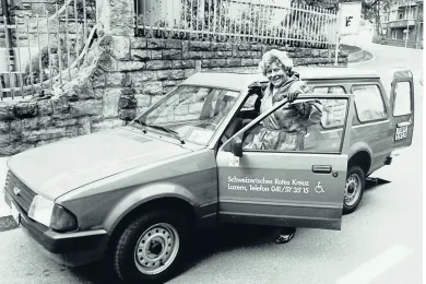 Schwarz-Weiss-Foto: Eine Freiwillige als Fahrerin des SRK-Fahrdienstes