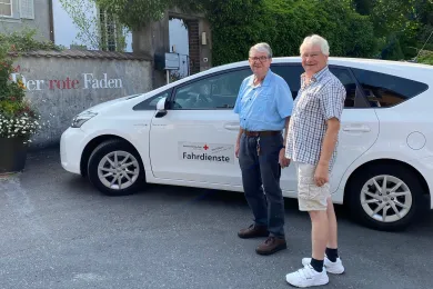Ein Freiwilliger vom Fahrdienst ist mit einem Klienten unterwegs