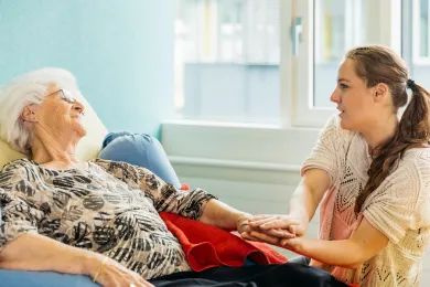 Eine Person pflegt eine ältere Person