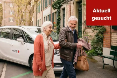 Ein Freiwilliger begleitet eine Kundin vom Rotkreuz-Fahrdienst