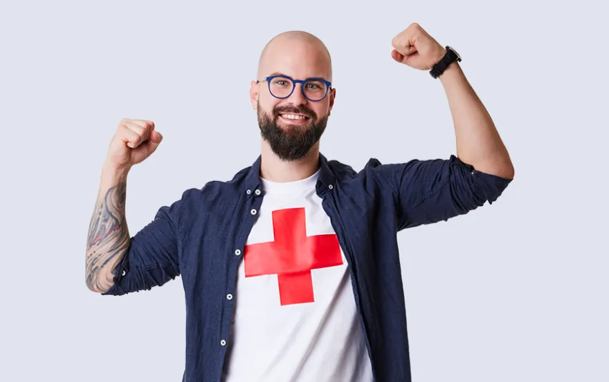 Der Freiwillige Kevin Schatzmann posiert mit einem Rotkreuz-Shirt